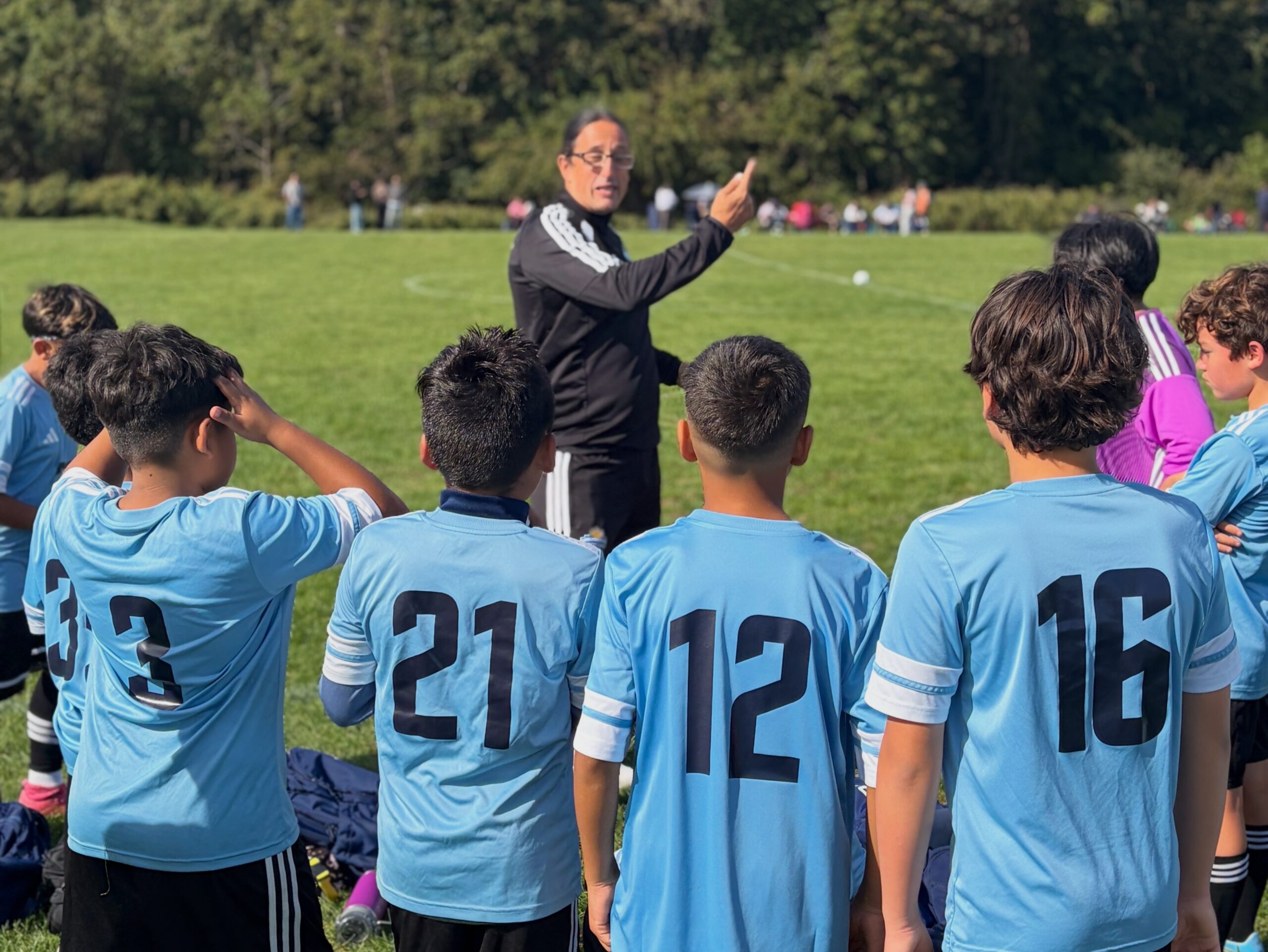 Uruguayan Soccer Academy coach giving instructions to players.