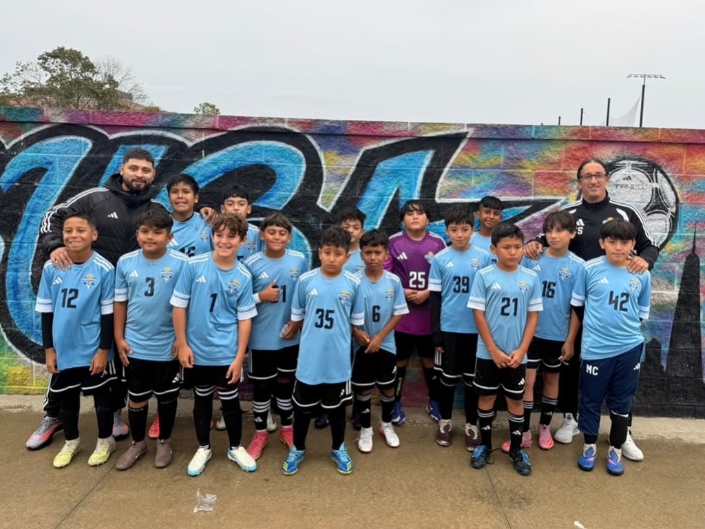 Uruguayan Soccer Academy team in sky-blue uniforms with their coaches.